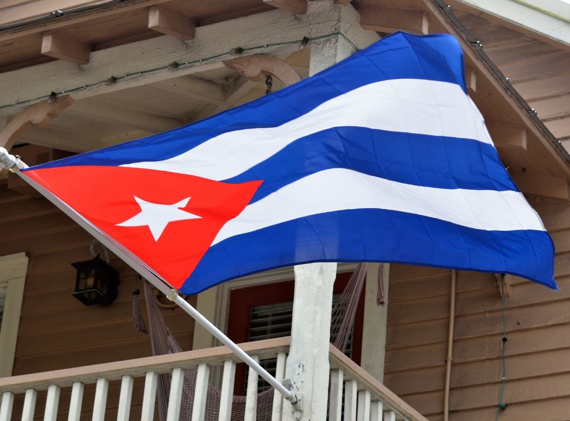 Bandera de Cuba ondeando en el frente de una propiedad de madera.
